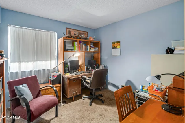 a view of a workspace with furniture and a window