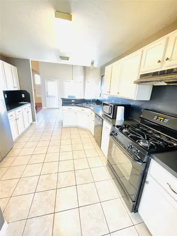 a kitchen with a stove a sink and a counter top space
