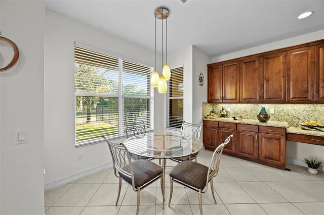 a kitchen with a stove a sink a microwave a dining table and chairs