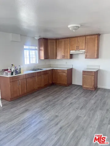 a large kitchen with stainless steel appliances granite countertop a sink and wooden floor