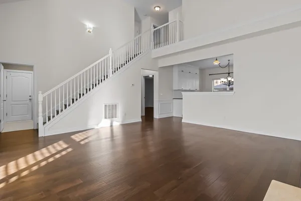 a view of staircase and kitchen with wooden floor