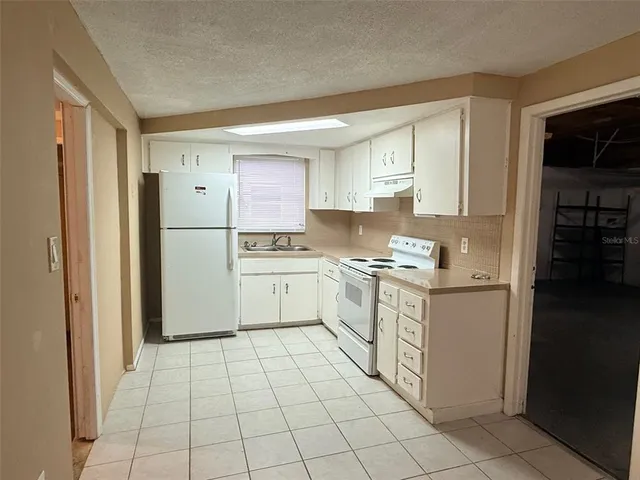 a kitchen with white cabinets and white appliances