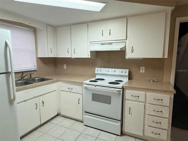 a kitchen with cabinets appliances a sink and a counter top