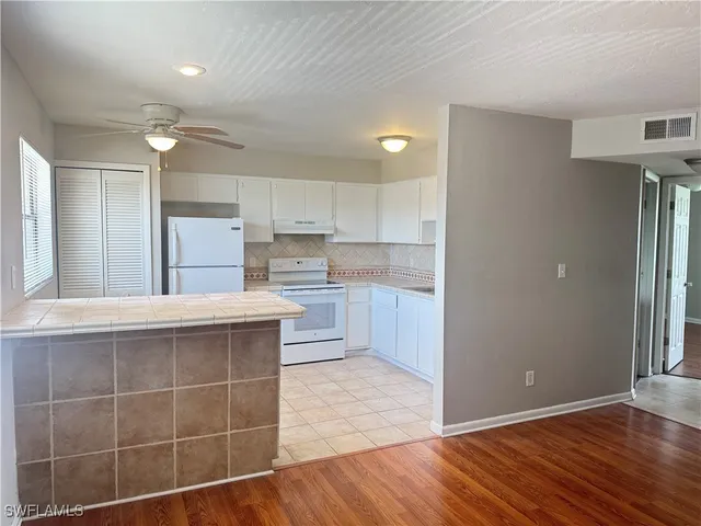 a kitchen with kitchen island granite countertop a refrigerator and a sink