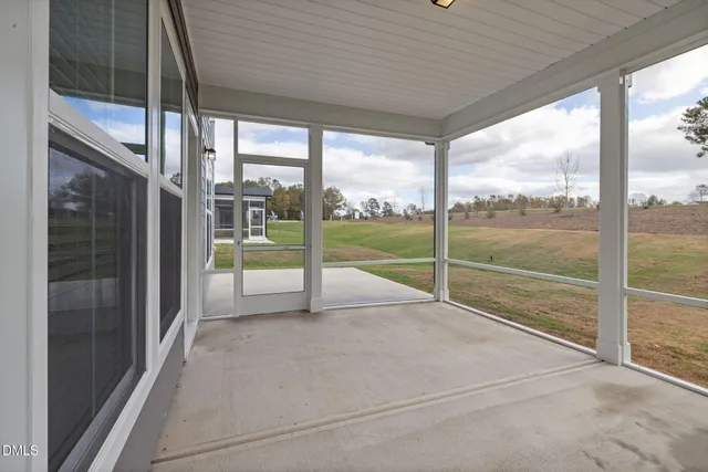 a view of an empty room with sliding glass door and mountain view from a ceiling window