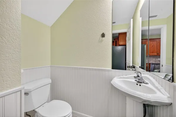 an empty room with wooden floor chandelier fan and windows