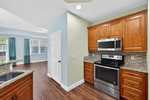 a kitchen with granite countertop a sink cabinets and wooden floor