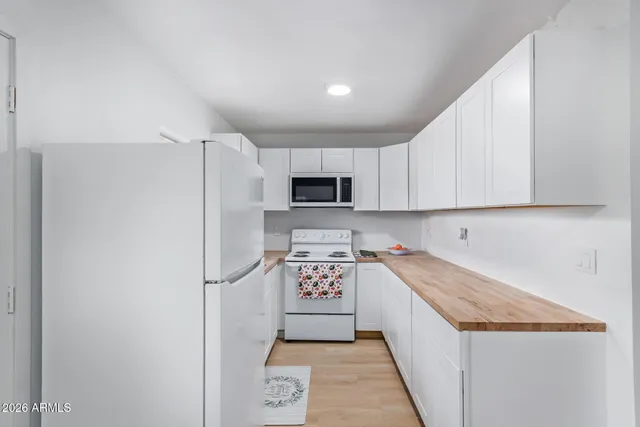 a kitchen with a refrigerator a microwave and cabinets