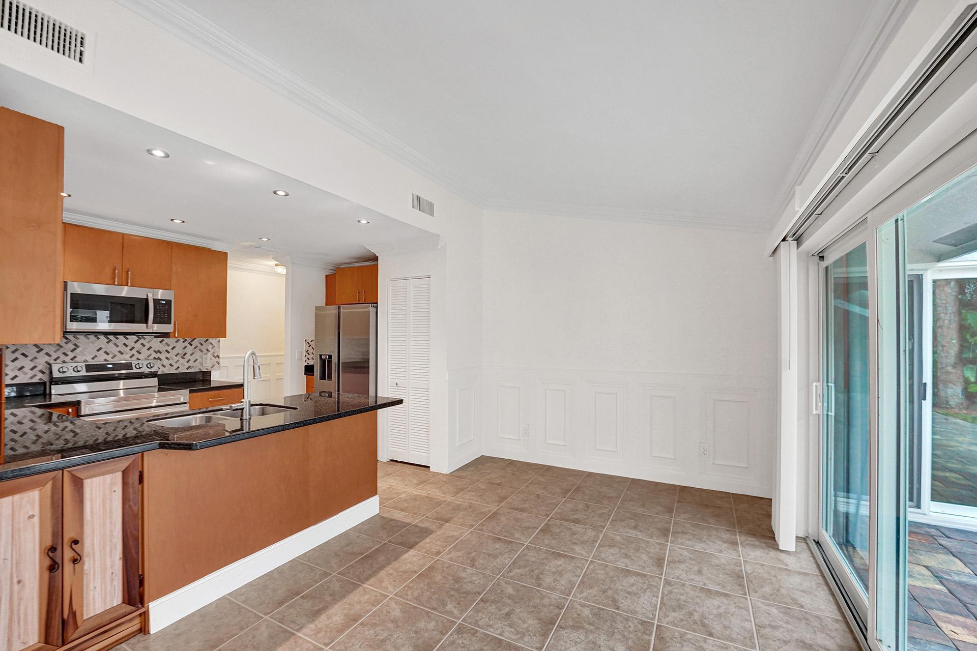 2941 Northwest 24th Way Boca Raton, FL 33431 - Photo 16 of 53 a kitchen with stainless steel appliances a sink stove and cabinets