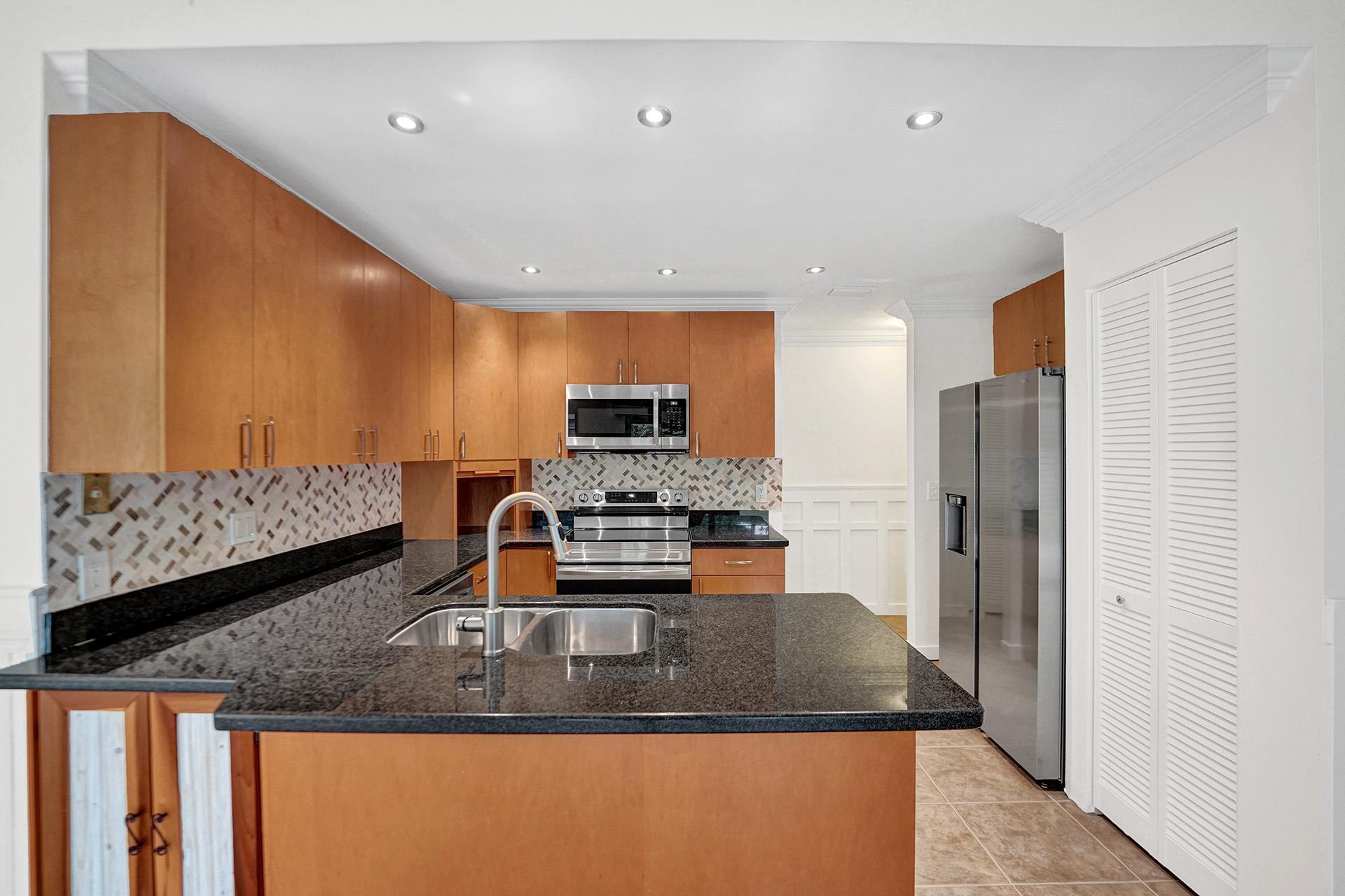 2941 Northwest 24th Way Boca Raton, FL 33431 - Photo 18 of 53 a kitchen with stainless steel appliances granite countertop a sink refrigerator and microwave