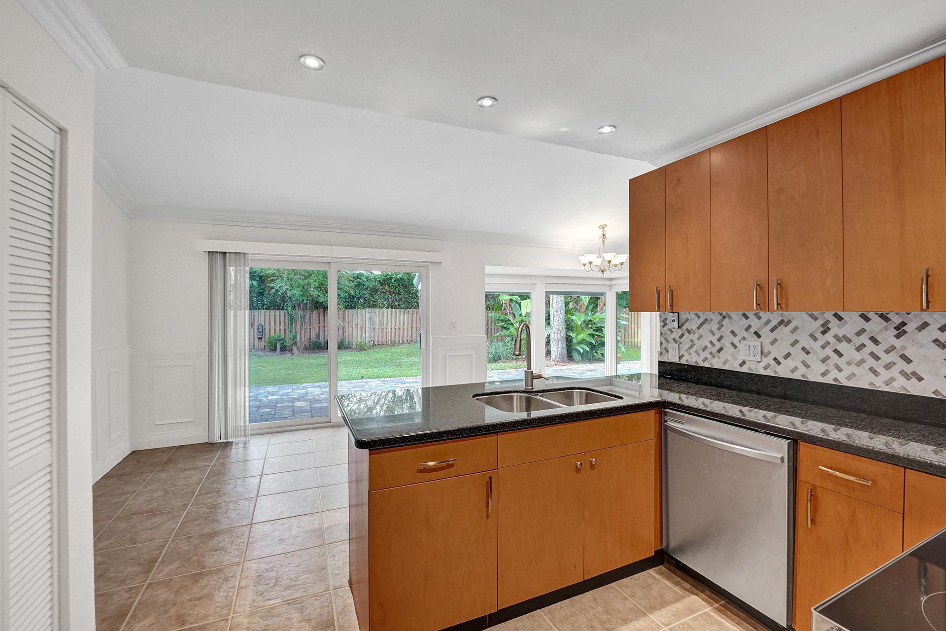 2941 Northwest 24th Way Boca Raton, FL 33431 - Photo 19 of 53 a kitchen with granite countertop a stove a sink and a cabinets