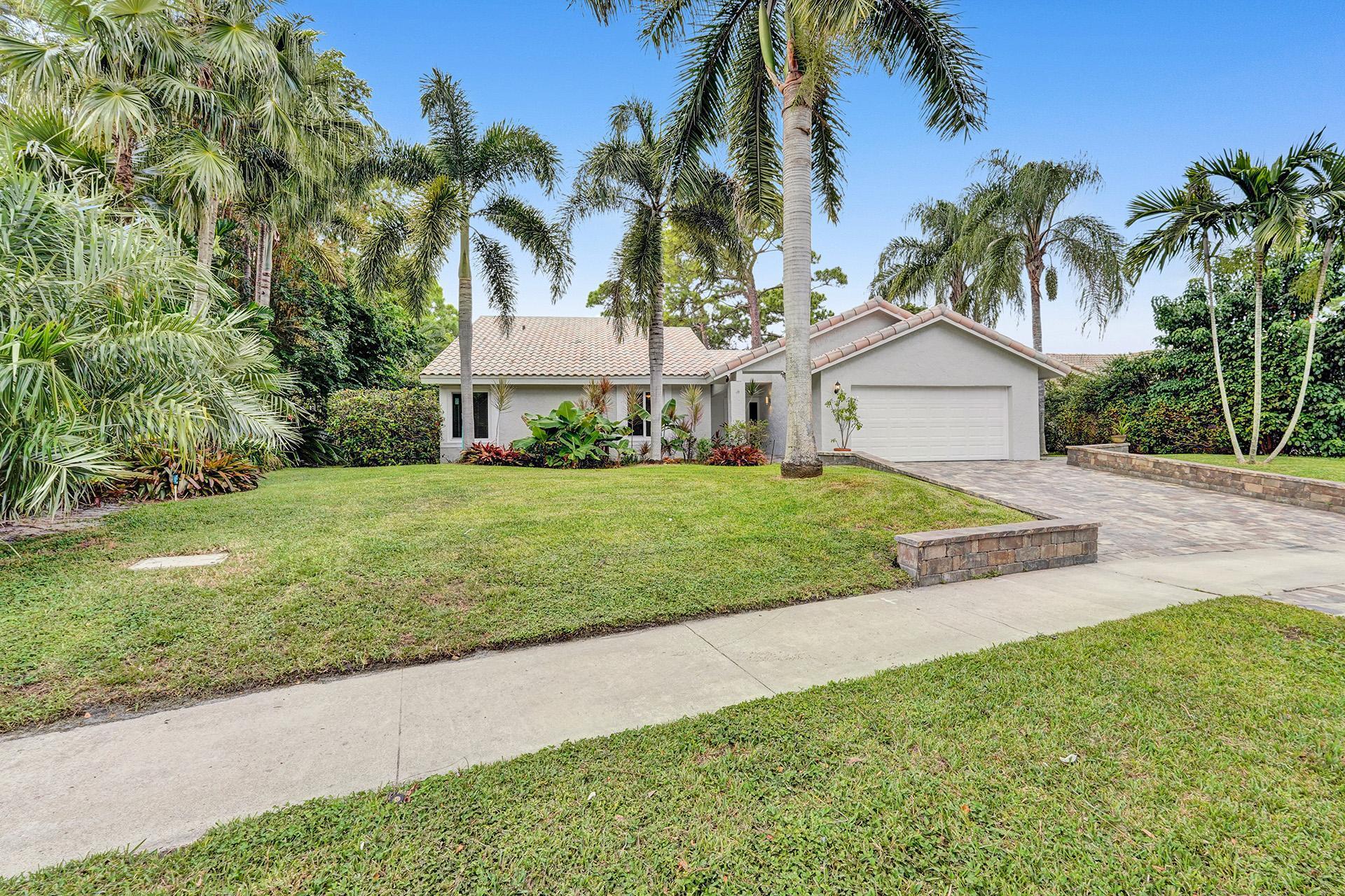 2941 Northwest 24th Way Boca Raton, FL 33431 - Photo 2 of 53 a view of a white house with a big yard and palm trees