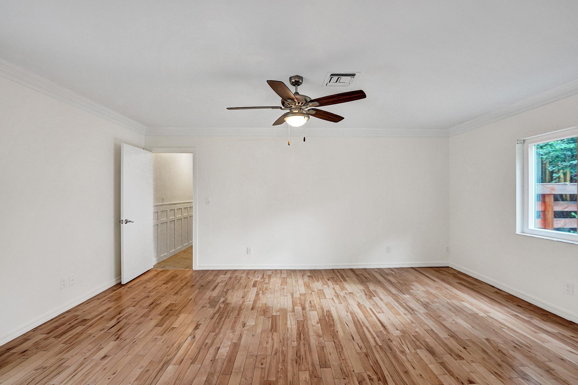 2941 Northwest 24th Way Boca Raton, FL 33431 - Photo 26 of 53 an empty room with wooden floor and a ceiling fan