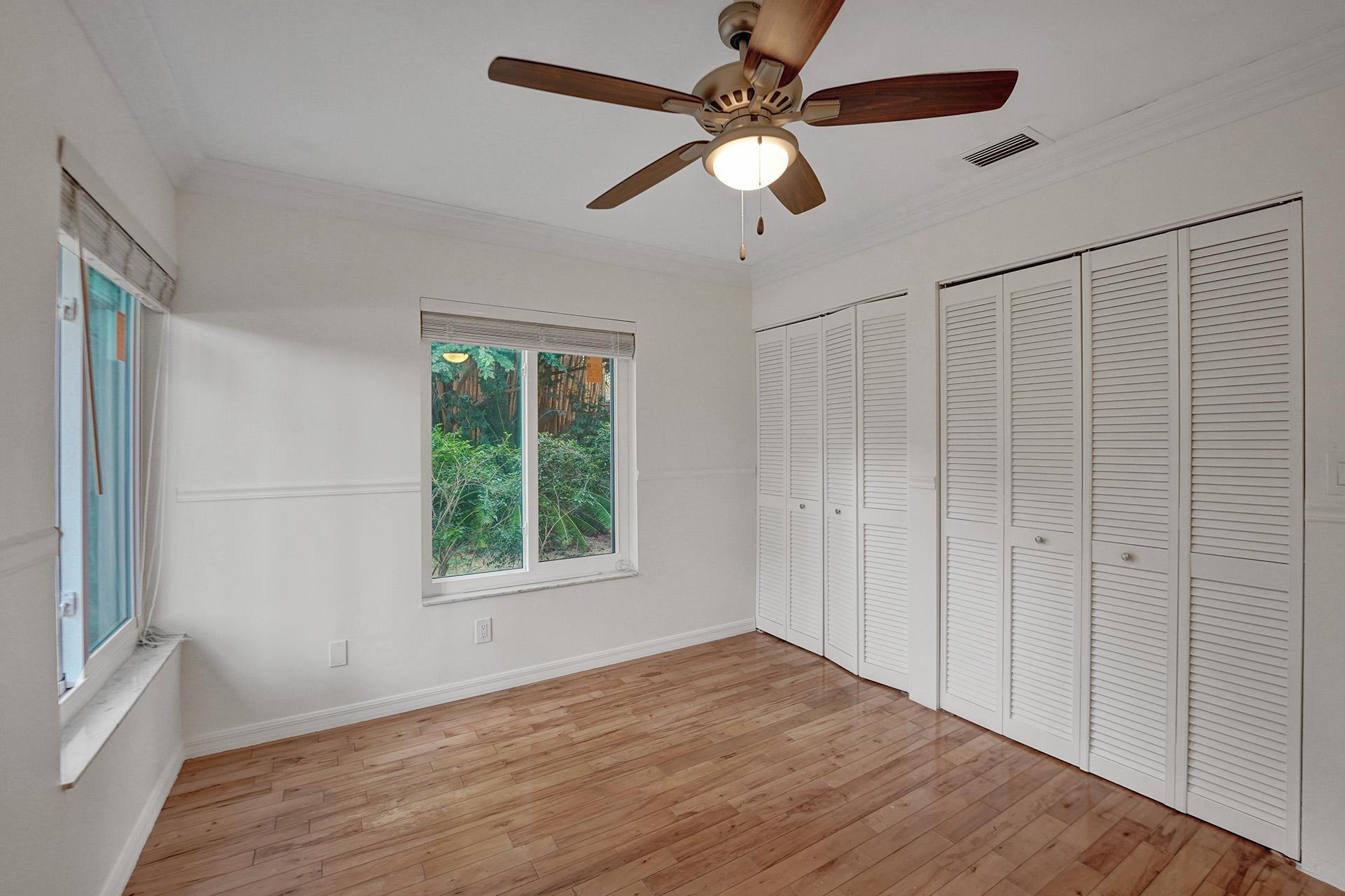 2941 Northwest 24th Way Boca Raton, FL 33431 - Photo 40 of 53 an empty room with wooden floor fan and windows