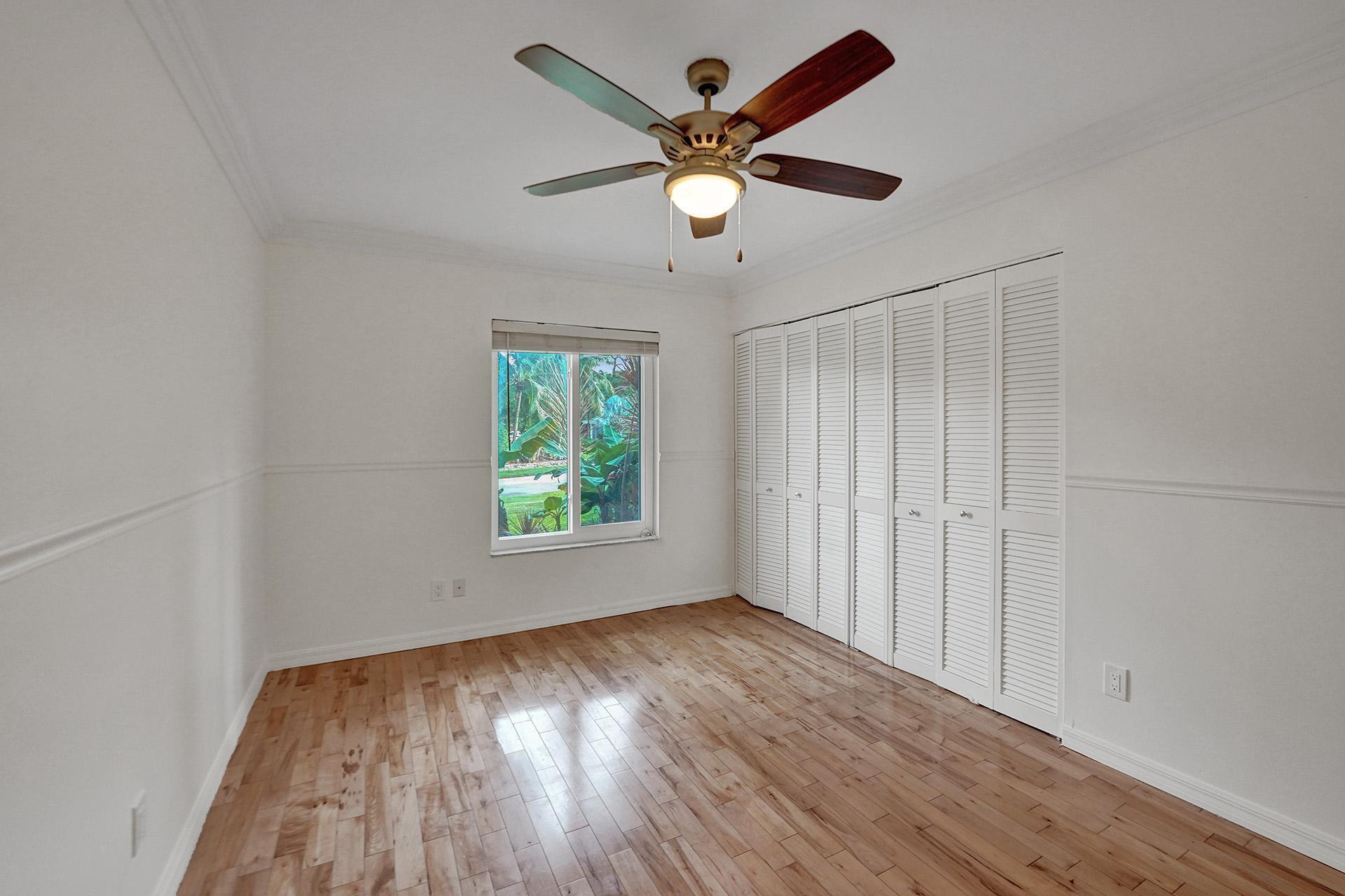 2941 Northwest 24th Way Boca Raton, FL 33431 - Photo 44 of 53 an empty room with wooden floor fan and windows