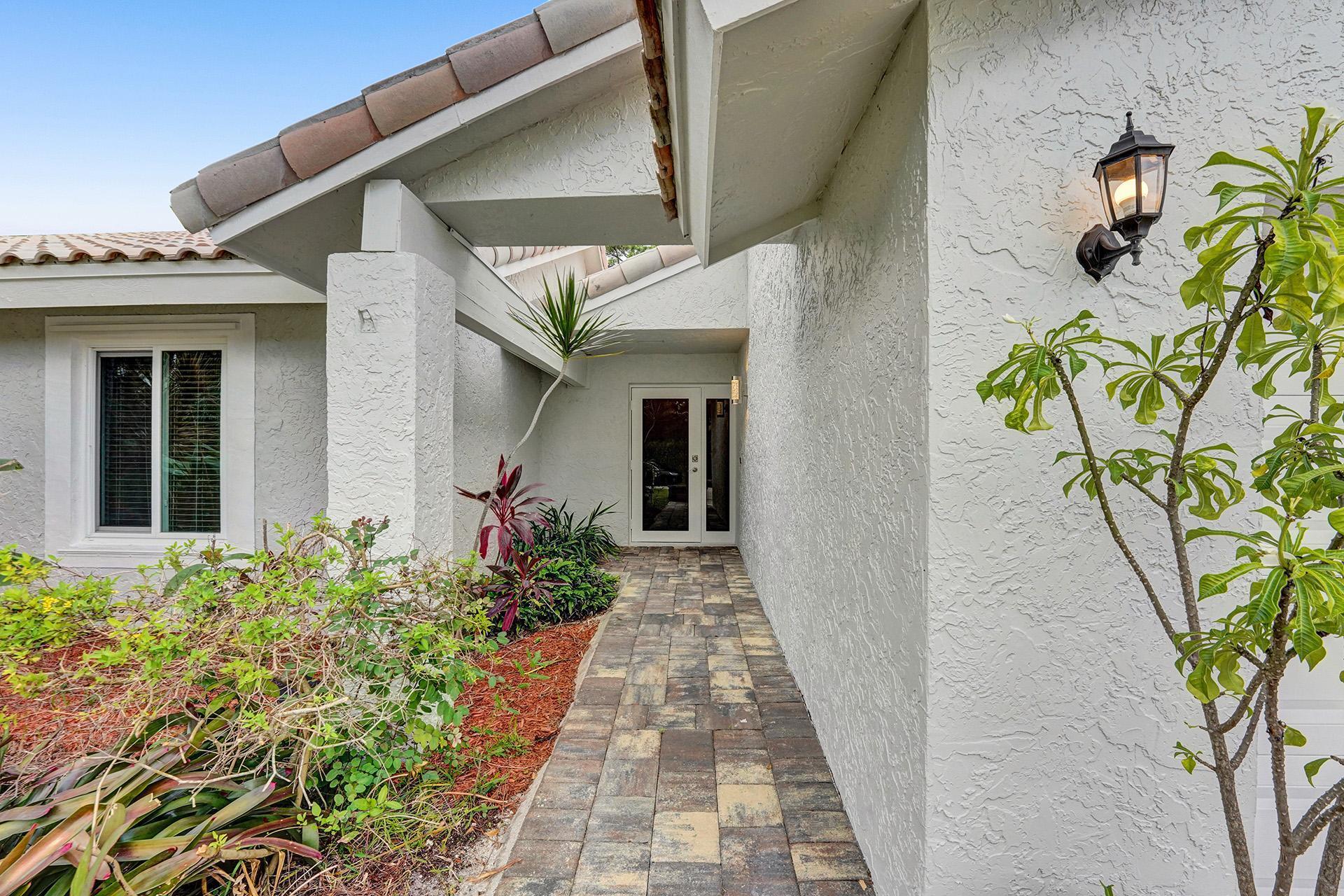 2941 Northwest 24th Way Boca Raton, FL 33431 - Photo 5 of 53 a front view of a house with a garden