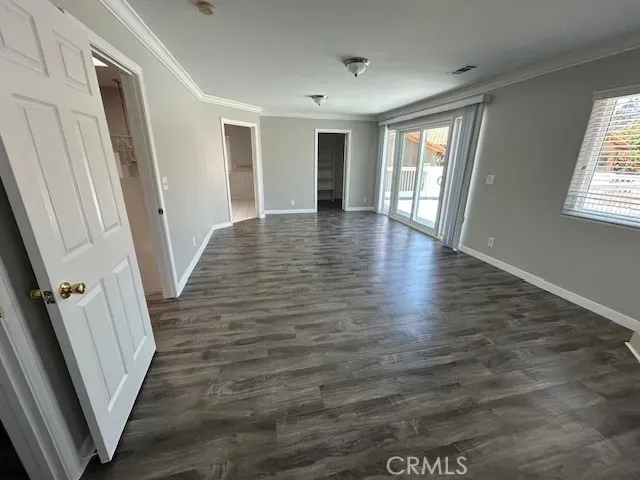 a view of an empty room with wooden floor and stairs