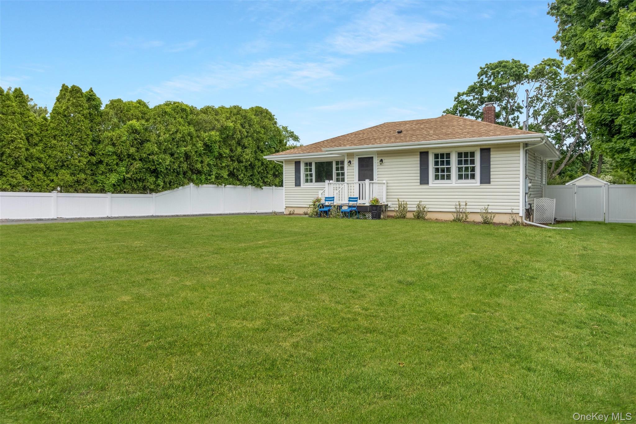 315 Wicks Road New Suffolk, NY 11956 - Photo 24 of 28 a front view of a house with a garden and yard