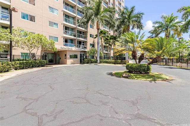 a view of a building with a yard and palm trees