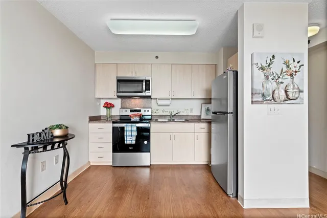 a kitchen with a refrigerator and a stove top oven