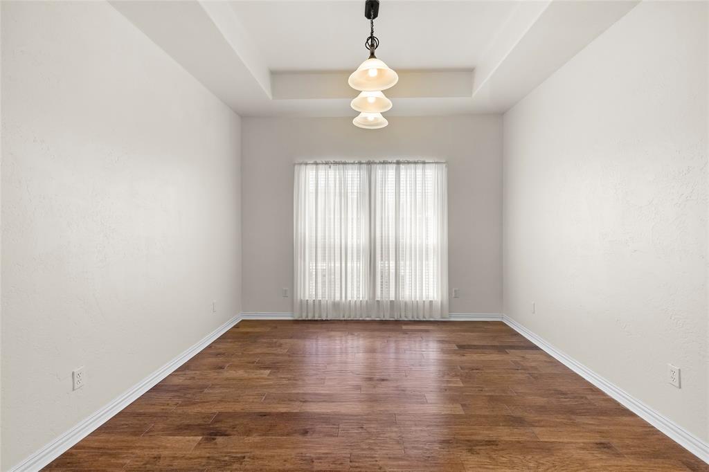 1308 Madeline Street Commerce, TX 75428 - Photo 12 of 37 an empty room with wooden floor and windows