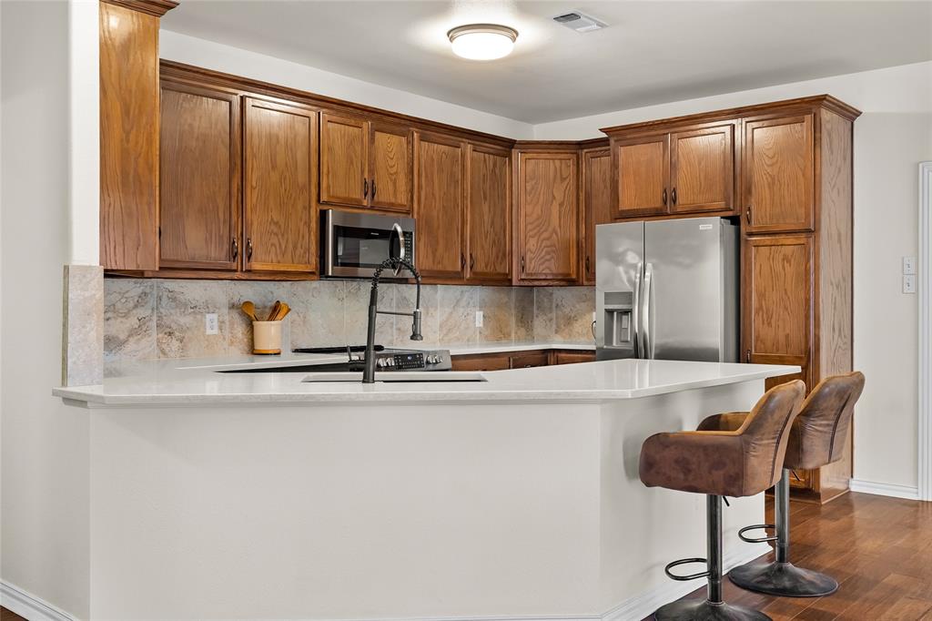 1308 Madeline Street Commerce, TX 75428 - Photo 16 of 37 a kitchen with stainless steel appliances granite countertop a refrigerator and a stove top oven