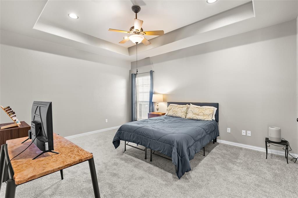 1308 Madeline Street Commerce, TX 75428 - Photo 20 of 37 a bedroom with a bed and a table in it