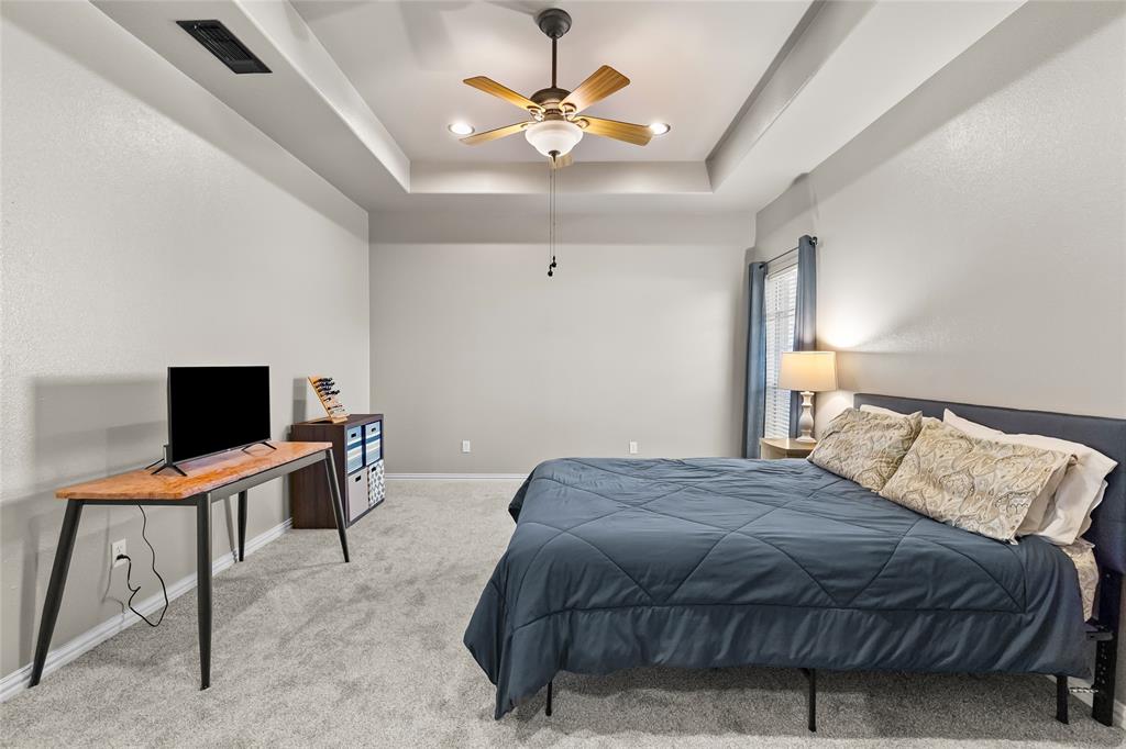 1308 Madeline Street Commerce, TX 75428 - Photo 21 of 37 a bedroom with a bed and a desk