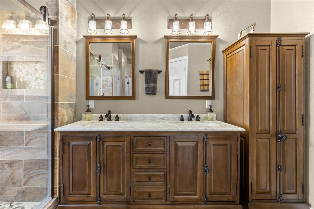 1308 Madeline Street Commerce, TX 75428 - Photo 22 of 37 a bathroom with a granite countertop sink and a mirror