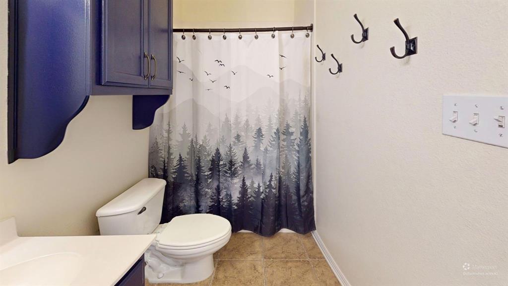 1308 Madeline Street Commerce, TX 75428 - Photo 27 of 37 a white toilet sitting next to a shower curtain