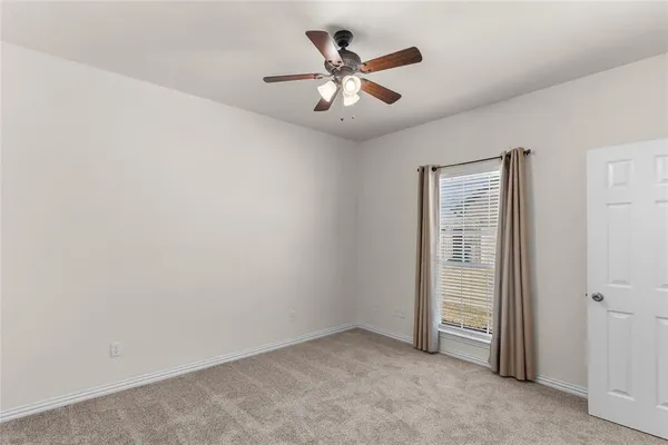 an empty room with closet and fan