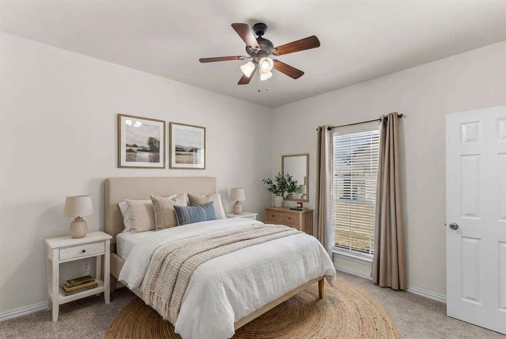 1308 Madeline Street Commerce, TX 75428 - Photo 28 of 37 a bedroom with a large bed and a chandelier
