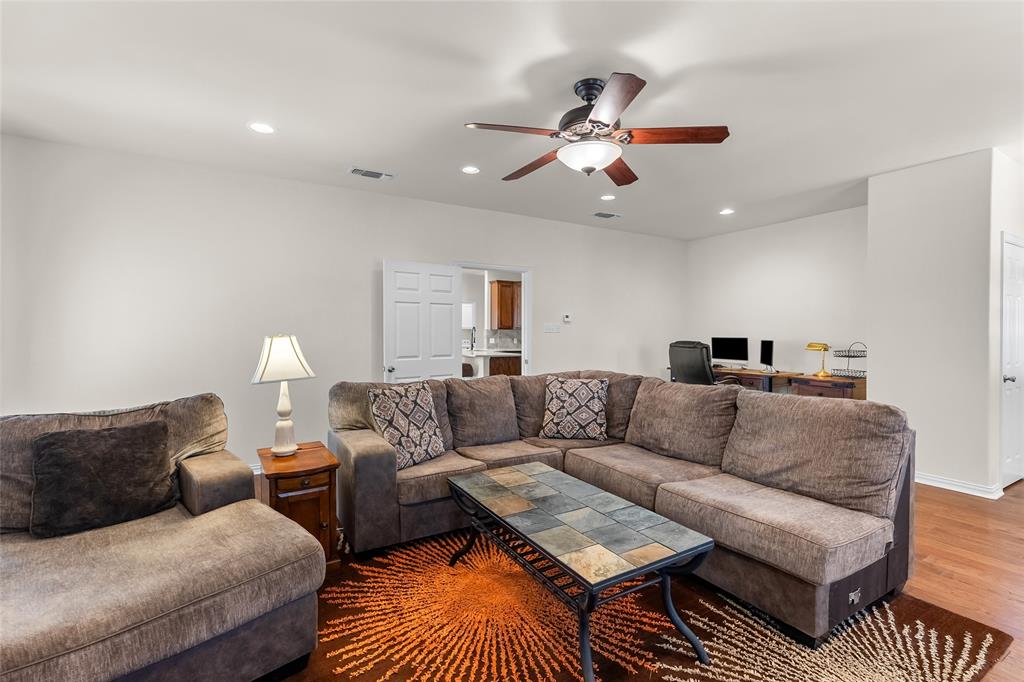 1308 Madeline Street Commerce, TX 75428 - Photo 9 of 37 a living room with furniture and a chandelier