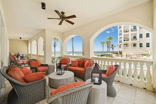 a living room with furniture a rug and a floor to ceiling window