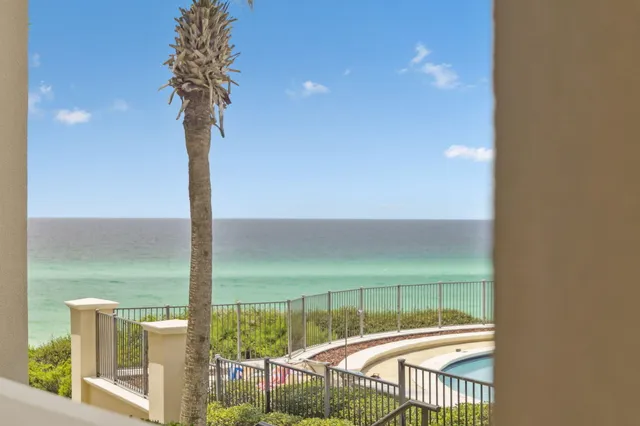 a view of a balcony with floor to ceiling window next to a yard