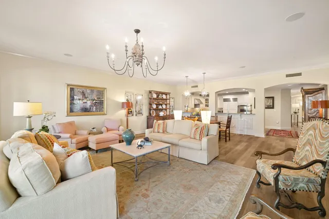 a living room with furniture chandelier and a table