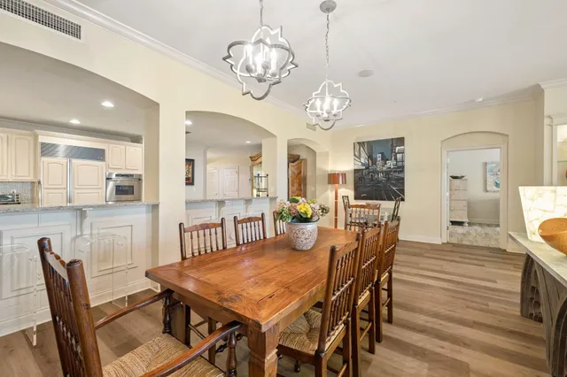 a view of a dining room with furniture a chandelier and wooden floor