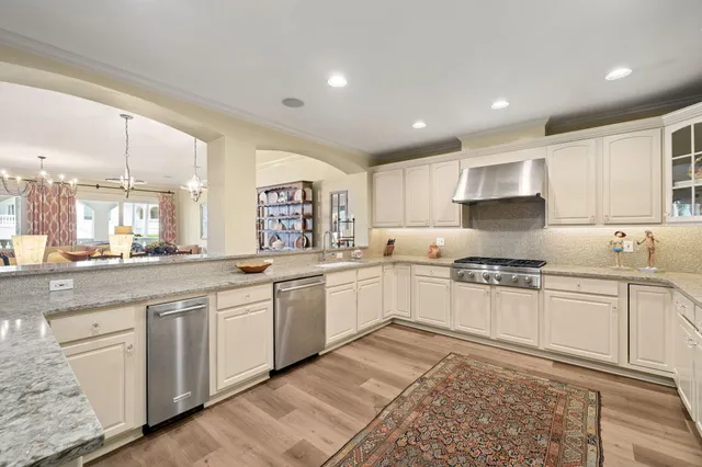 a large white kitchen with cabinets and wooden floor