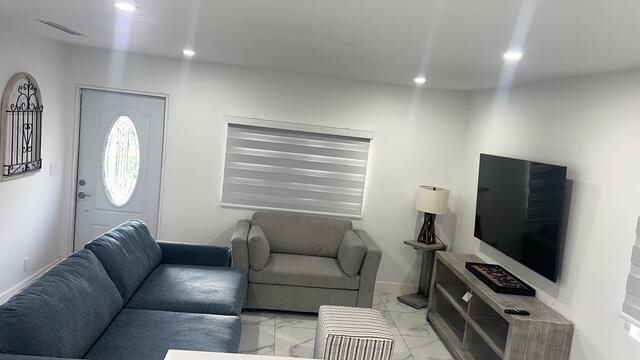 16355 Downers Drive East, Unit 2 Loxahatchee, FL 33470 - Photo 2 of 8 a living room with furniture a flat screen tv and a window