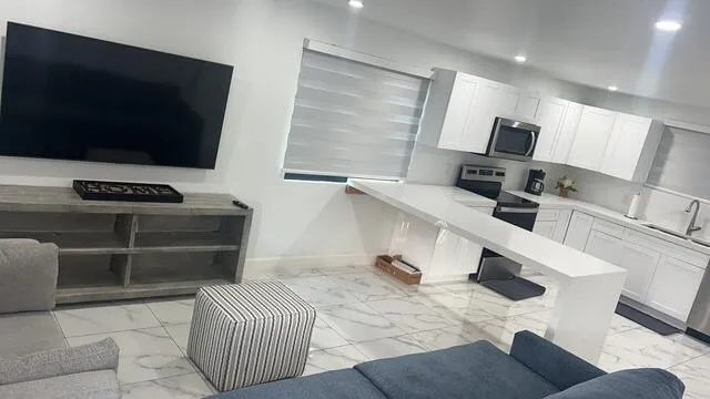 a room with a flat screen tv and view of living room