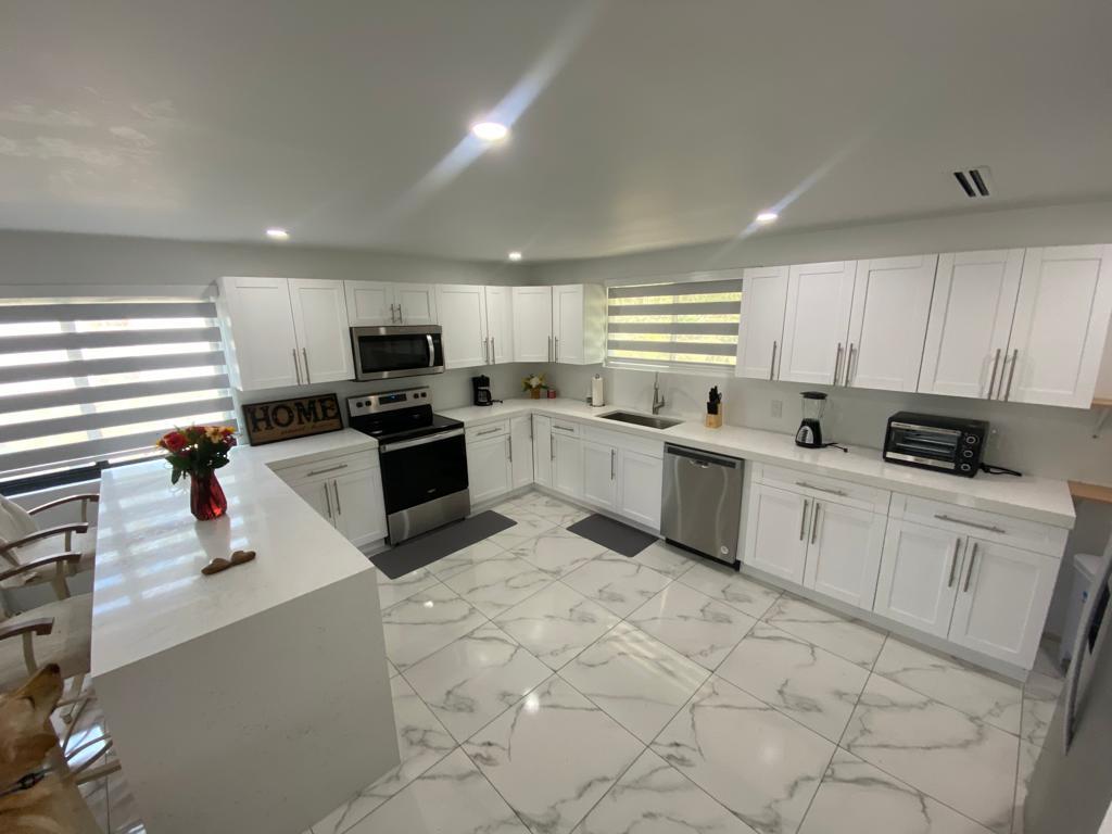 16355 Downers Drive East, Unit 2 Loxahatchee, FL 33470 - Photo 8 of 8 a kitchen with white cabinets appliances and a window