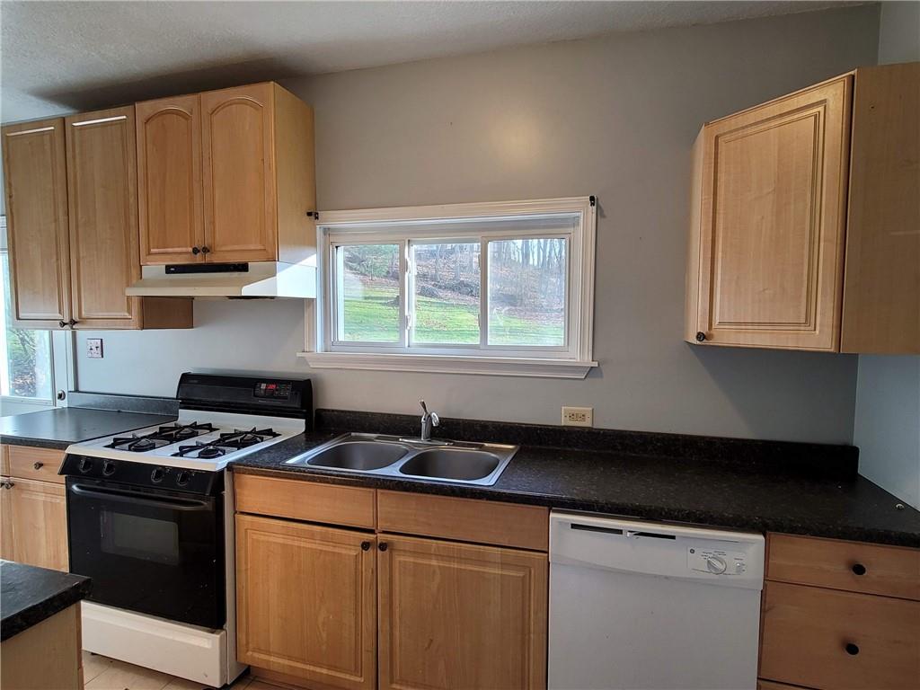 211 Summit Street Butler, PA 16001 - Photo 8 of 17 a kitchen with granite countertop a sink a stove and cabinets
