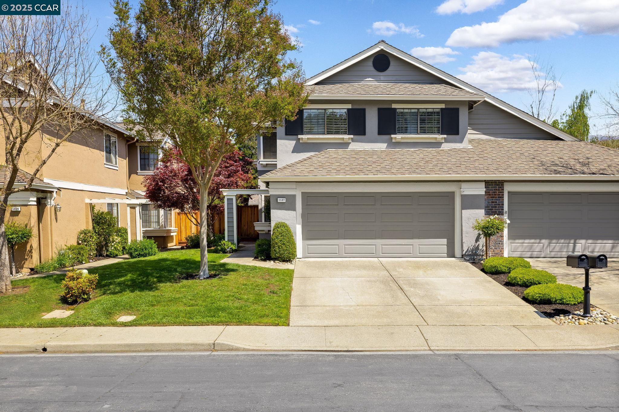 a front view of a house with a yard and garage