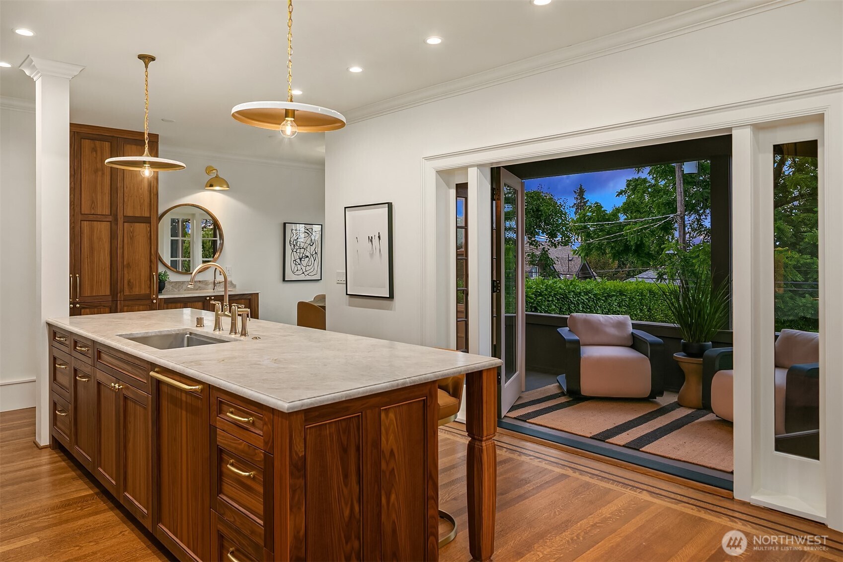 740 22nd Avenue East Seattle, WA 98112 - Photo 16 of 40 a hall with kitchen island a large window cabinets a sink and stainless steel appliances