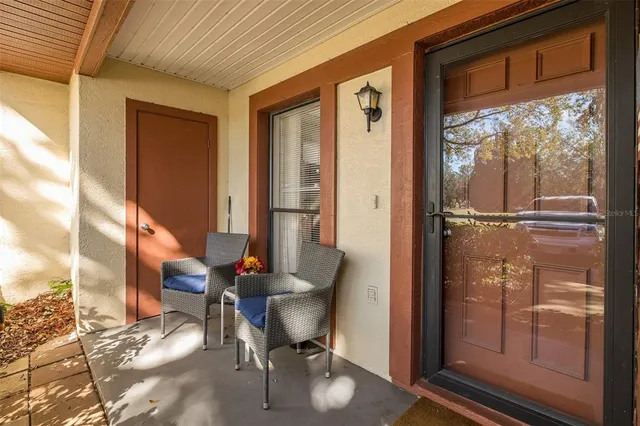 a view of swimming pool with outdoor seating and trees in the background