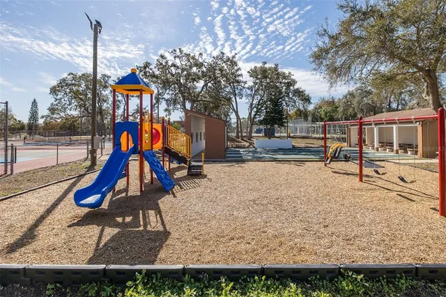 a view of a tennis ground with large trees