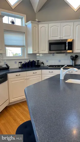 a kitchen with stainless steel appliances granite countertop a sink a stove top oven a counter space and cabinets