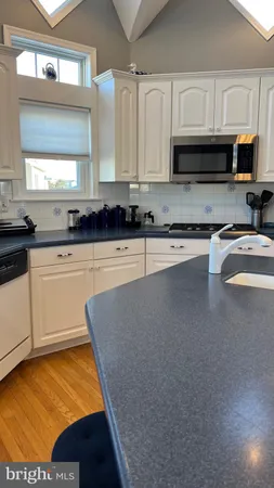 a kitchen with stainless steel appliances granite countertop a sink a stove top oven a counter space and cabinets
