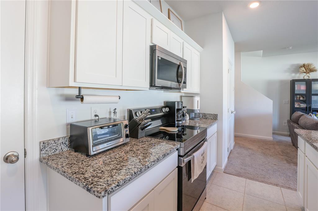 2240 Hemingway Circle Groveland, FL 34736 - Photo 14 of 34 a kitchen with stainless steel appliances granite countertop a sink stove and refrigerator