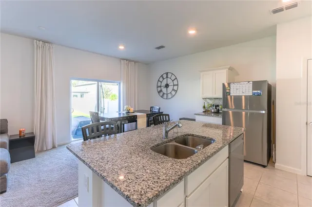 a kitchen with a sink a refrigerator and cabinets